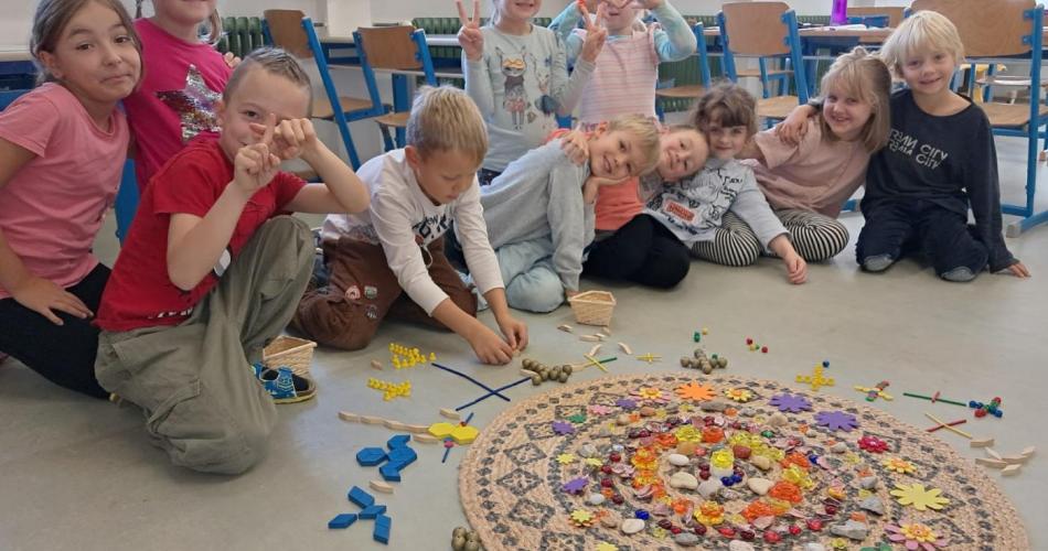 Kinder gestalten eine Mitte aus Kreuzen mit Legematerial